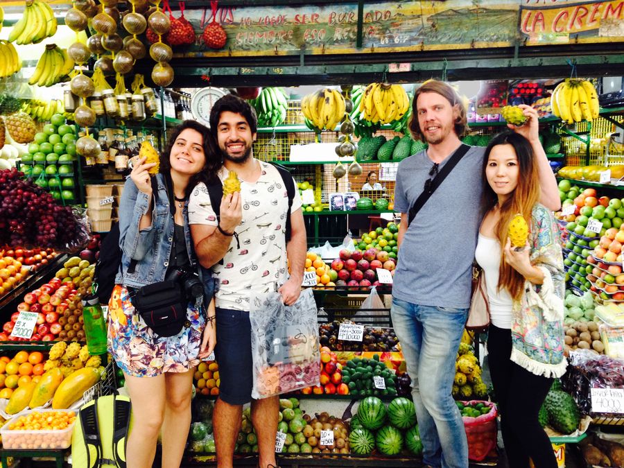 Tour group holding exotic fruits at Medellín market